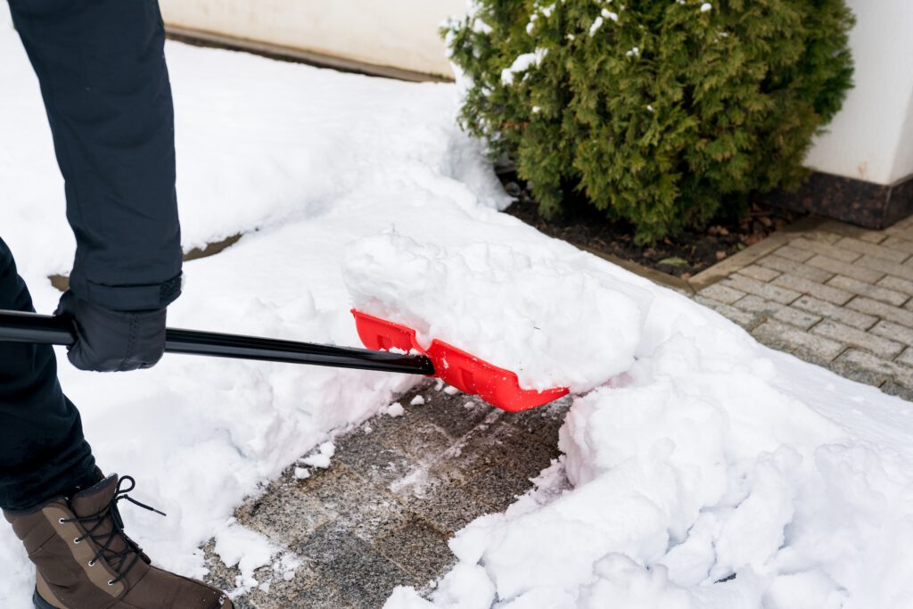 Close-up of man clearing snow and ice from the sidewalks. Shoveling snow after record storm